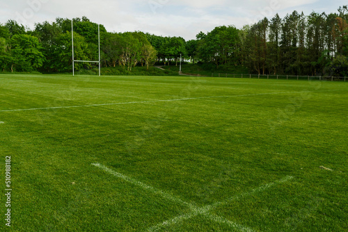 Green field with tall goal post for Irish National sport hurling and camogie in a park. Popular activity in Ireland for man, woman and children.