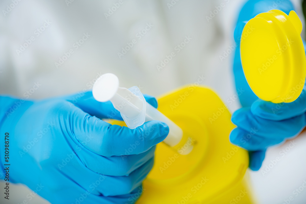 Medical Waste Biohazard. Throwing Away Syringe in Container for Biological Hazardous Material