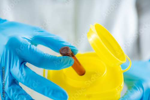 Medical Waste. Throwing Away Laboratory Consumables in Container for Hazardous Medical Waste.