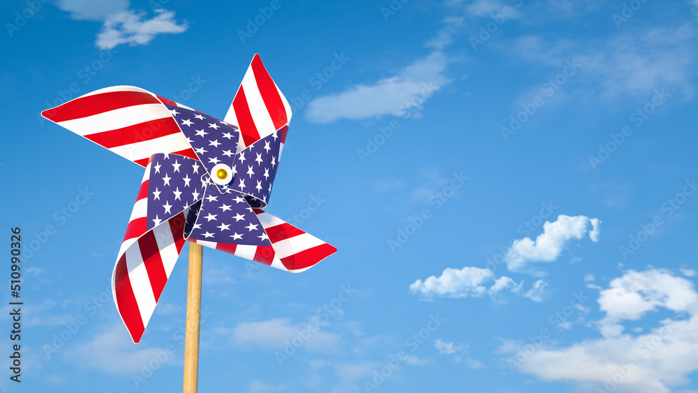 Pinwheel or windmill with USA flag as texture against bright blue sky. American's happiness concept.