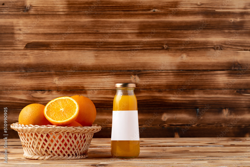 Naklejka premium Orange fruit and orange juice on wooden background
