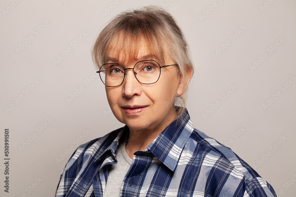 Attractive senior woman studio portrait while looking at camera and smiling