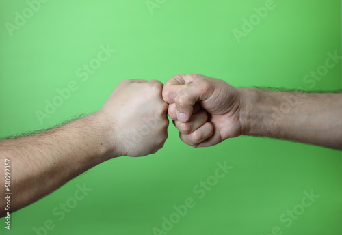 A man making hand signals on green background.