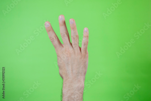 A man making hand signals on green background.