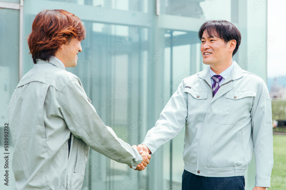 Fototapeta premium 握手する作業着姿のビジネスマン（建設・工業） 