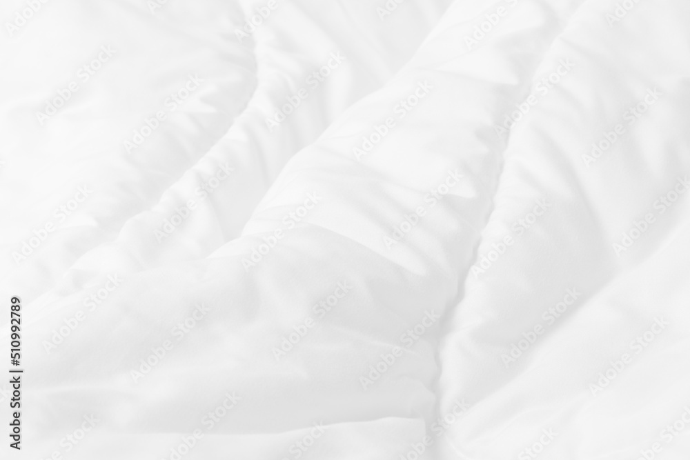 Obraz premium Close up top view of white bedding sheet and wrinkle messy blanket in bedroom after wake up in the morning.