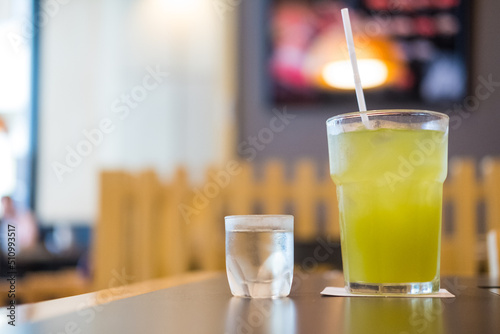 A glass of cold iced tea and syrup shot.