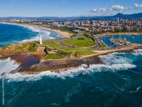 Aerial drone view of Flagstaff Point Lighthouse at Wollongong on the New South Wales South Coast, Australia with Wollongong city in the back ground on a sunny day   