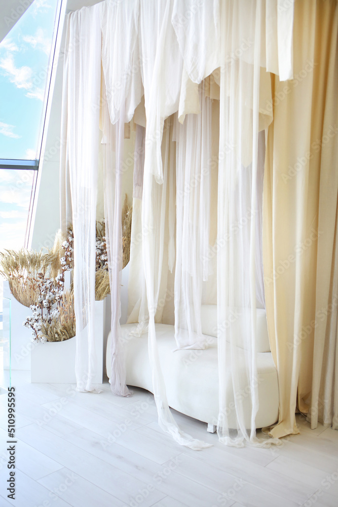 Sofa milky color and transparent curtains. Romantic setting. Modern home. Penthouses. Interior concept