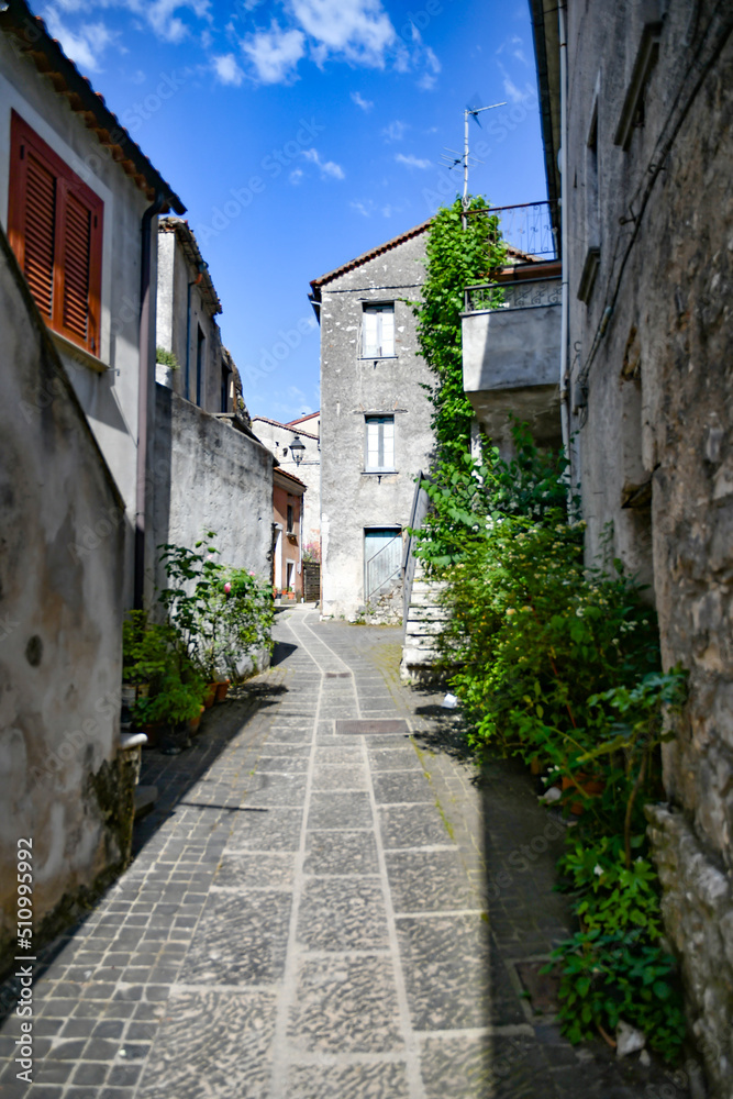 A narrow street between the old houses of Teggiano, a medieval village in the mountains of Salerno province, Italy.