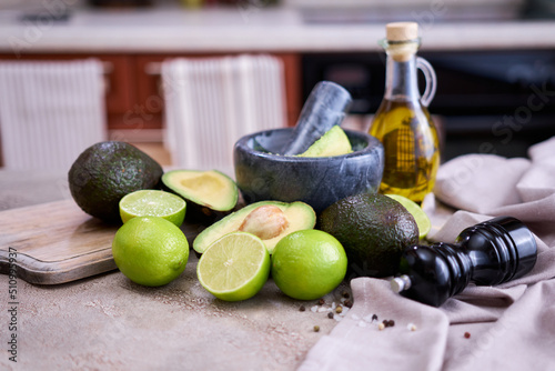 making guacamole - fresh sliced avocado in marble mortar on grey concrete table