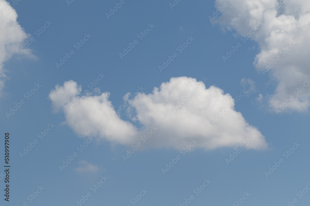 White clouds on the blue sky, bright background of the summer sky. White clouds on the blue sky, bright background of the summer sky.