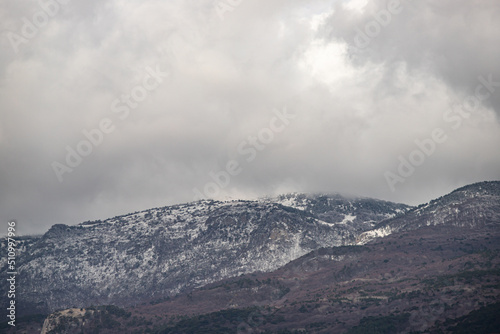 Snow-capped mountains against the background of the sky with clouds.