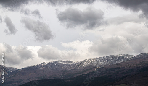 Snow-capped mountains against the background of the sky with clouds.