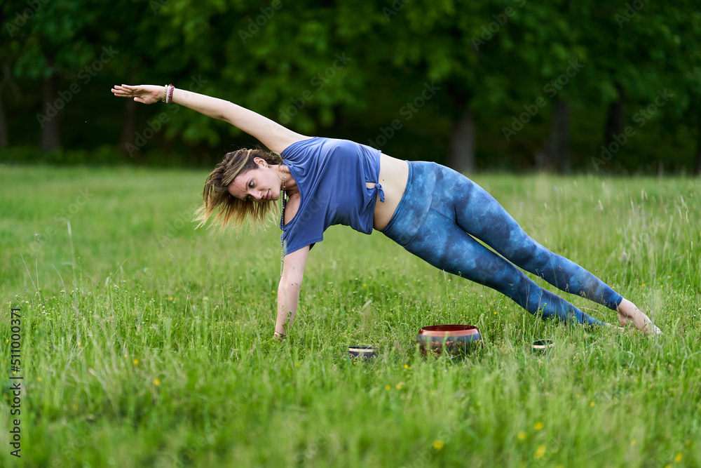 Young woman yoga practitioner in the forest