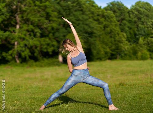 Young woman yoga practitioner in the forest