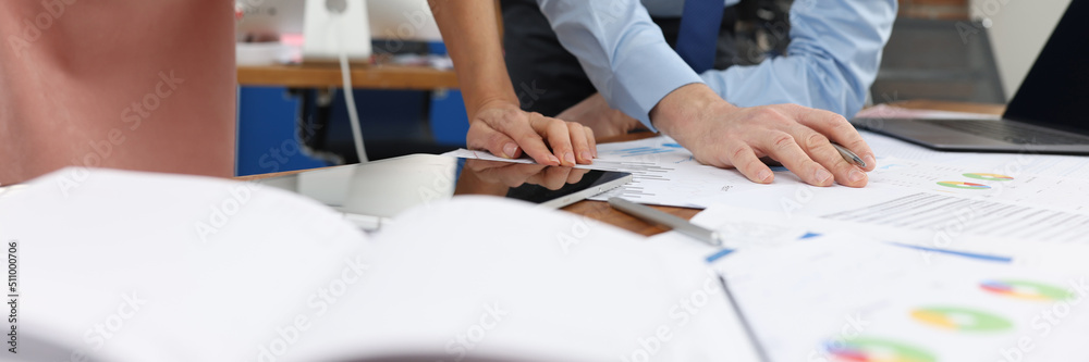 Business man and woman studying documents at table in office closeup