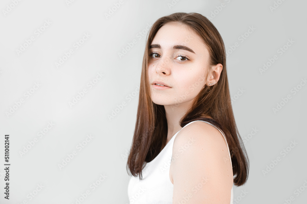 Young beautiful girl with clean skin. Women without wrinkles on the face close-up on a gray background Young beautiful girl with clean skin. Women without wrinkles on the face close-up on a gray background