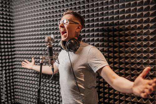 The vocalist sings in the studio in a microphone. Man in headphones writes a podcast, an audiobook. Artist, recording an album, working with the label. Announcer records a speech at a radio station