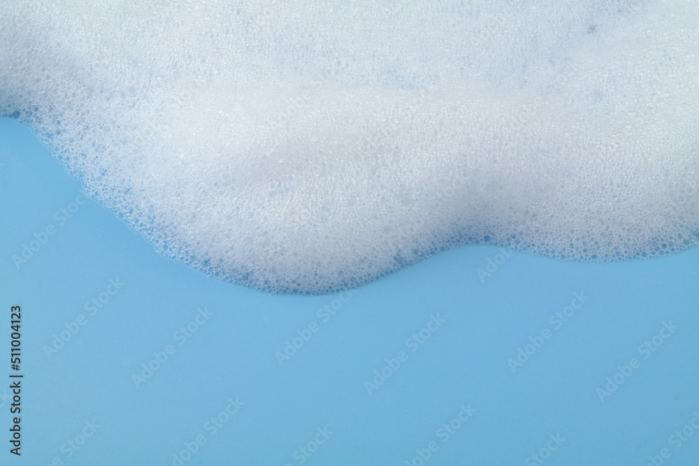 White soap or shampoo foam on blue background with copy space for text. White soap or shampoo foam on blue background with copy space for text.