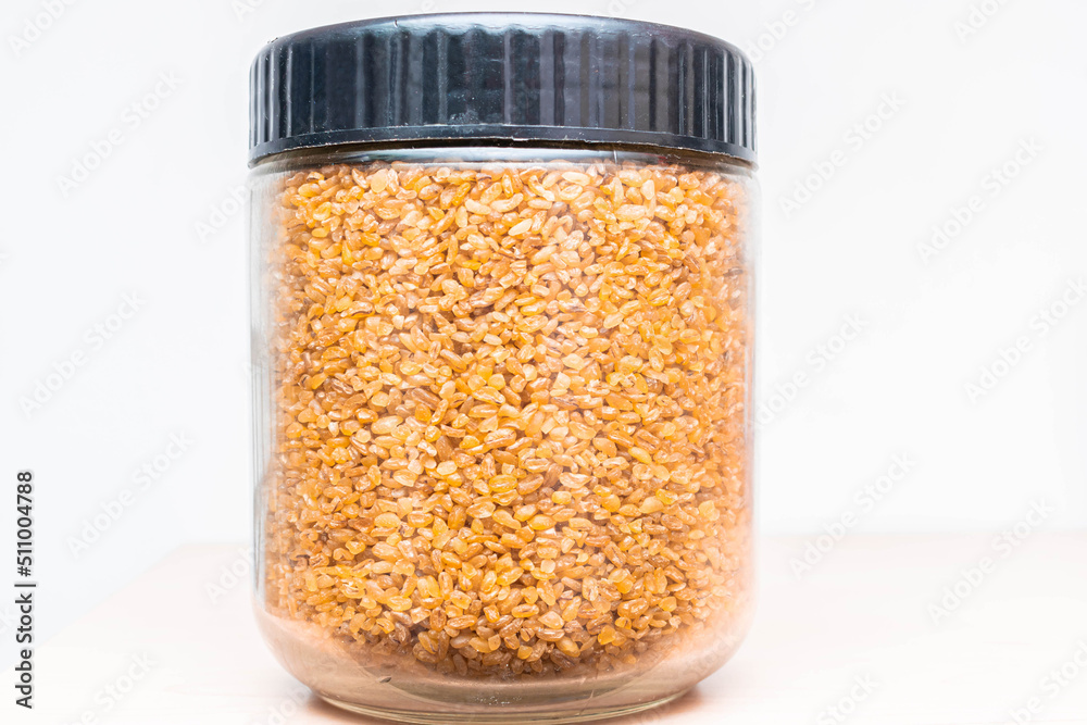 Bulgur groats are in a glass jar. Bulgur groats are in a glass jar.