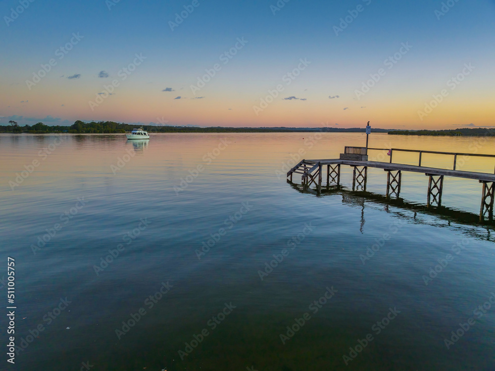 Sunset over the river with boat and wharf
