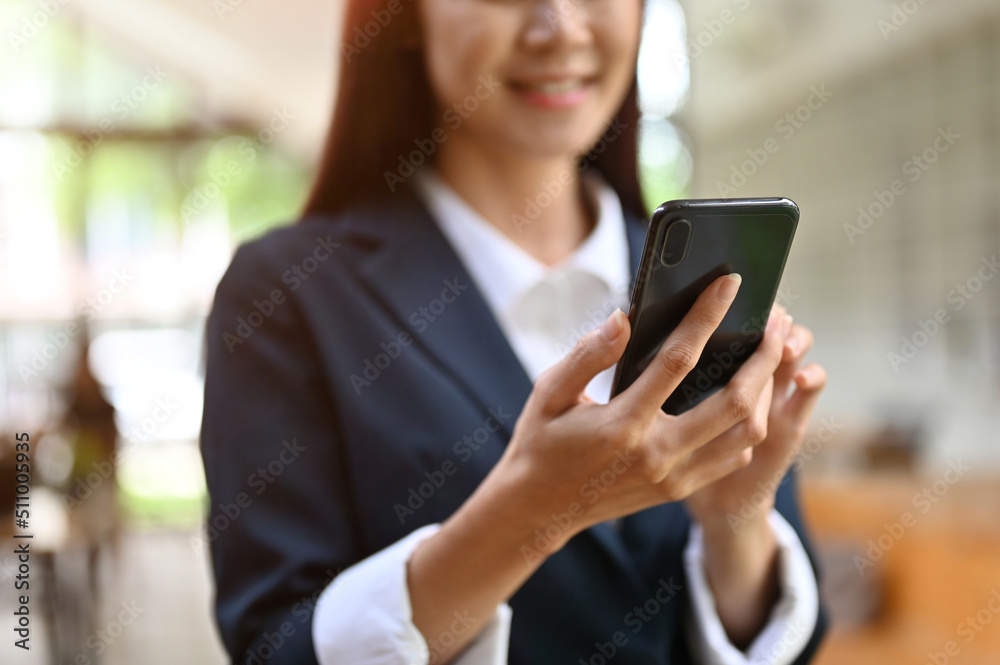 A beautiful young asian businesswoman using modern mobile phone in the office. A beautiful young asian businesswoman using modern mobile phone in the office.