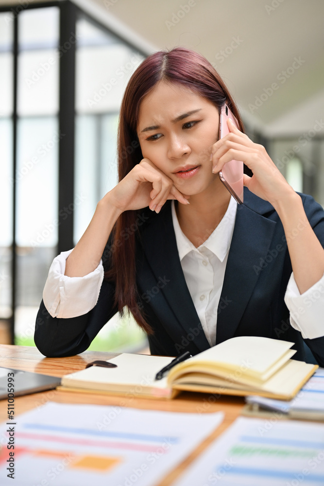 Businesswoman talking on the phone with a serious face expression. Arguing on the phone call. Businesswoman talking on the phone with a serious face expression. Arguing on the phone call.