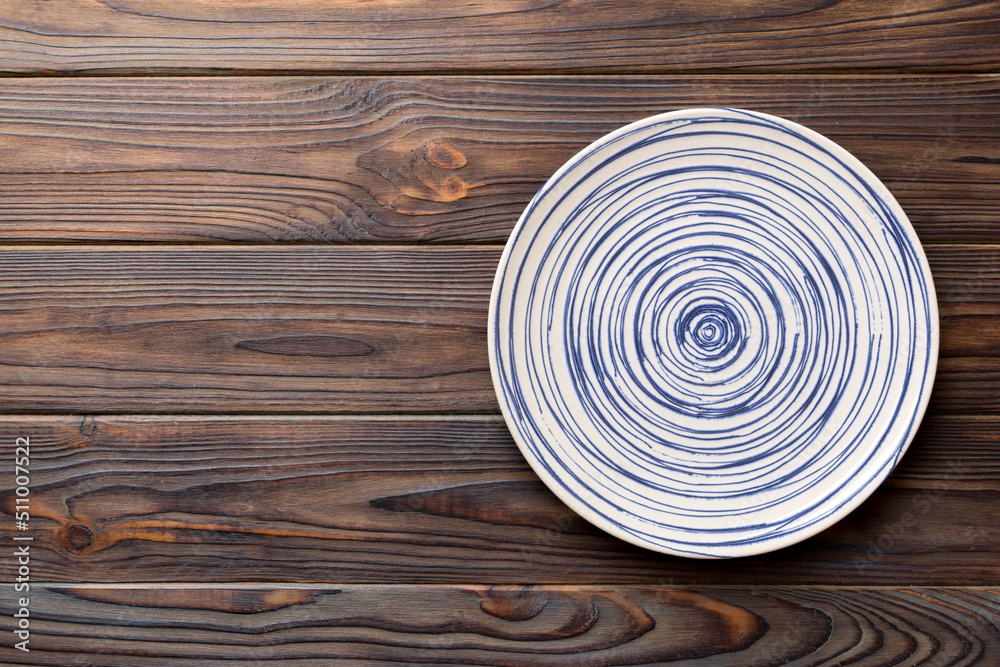 Top view of empty colorful plate on wooden background. Empty space for your design Top view of empty colorful plate on wooden background. Empty space for your design