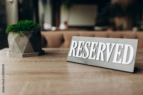 Restaurant reserved table sign standing on wooden table