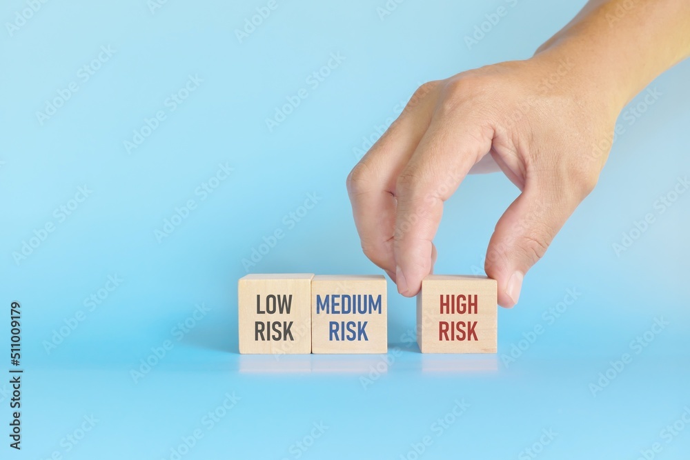 Investment risk management tolerance and planning and asset allocation and diversification concept. Wooden blocks with low, medium and high risk word with copy space.