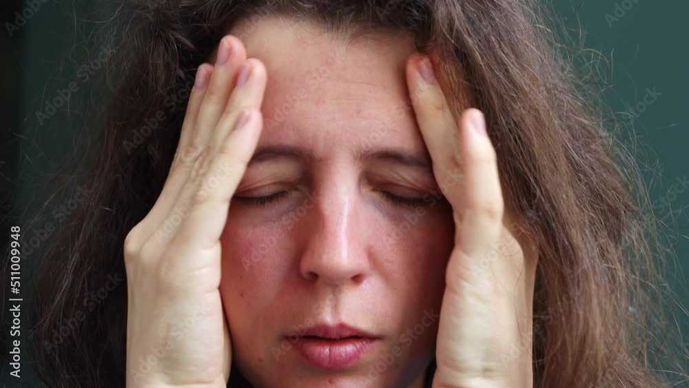 Close up frustrated young woman massaging temples touching aching head feeling strong headache or migraine, closed eyes, sitting indoors. Suffering pain. Tension and pressure concept Feeling stressed Close up frustrated young woman massaging temples touching aching head feeling strong headache or migraine, closed eyes, sitting indoors. Suffering pain. Tension and pressure concept Feeling stressed