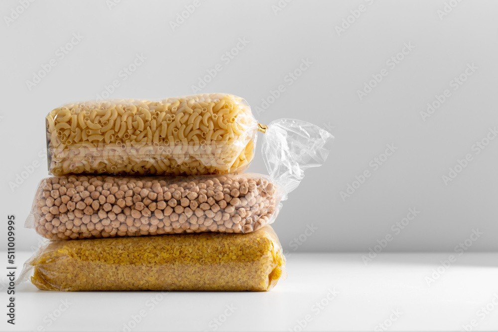 Fototapeta premium food, healthy eating and diet concept - bags with dried peas, pasta and bulgur on white background