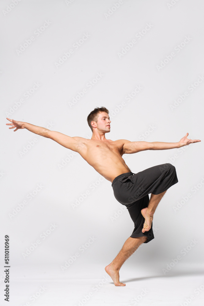 modern ballet male dancer posing over white studio background