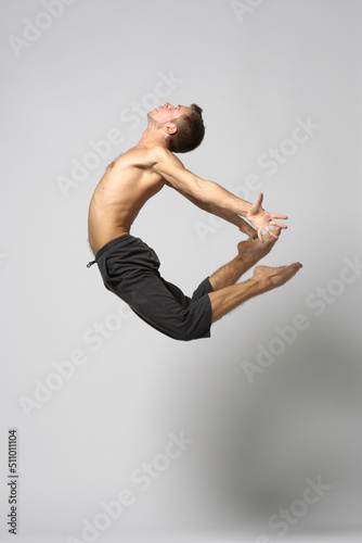 modern ballet male dancer posing over white studio background
