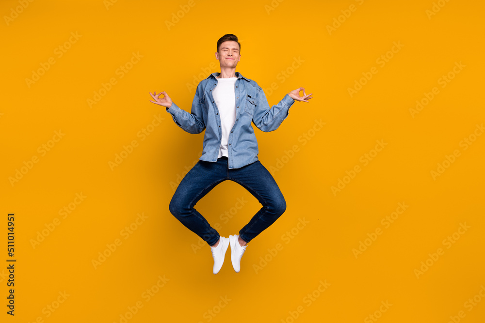 Photo of young man jump up meditate practicing relax dreamy fresh energy isolated over yellow color background