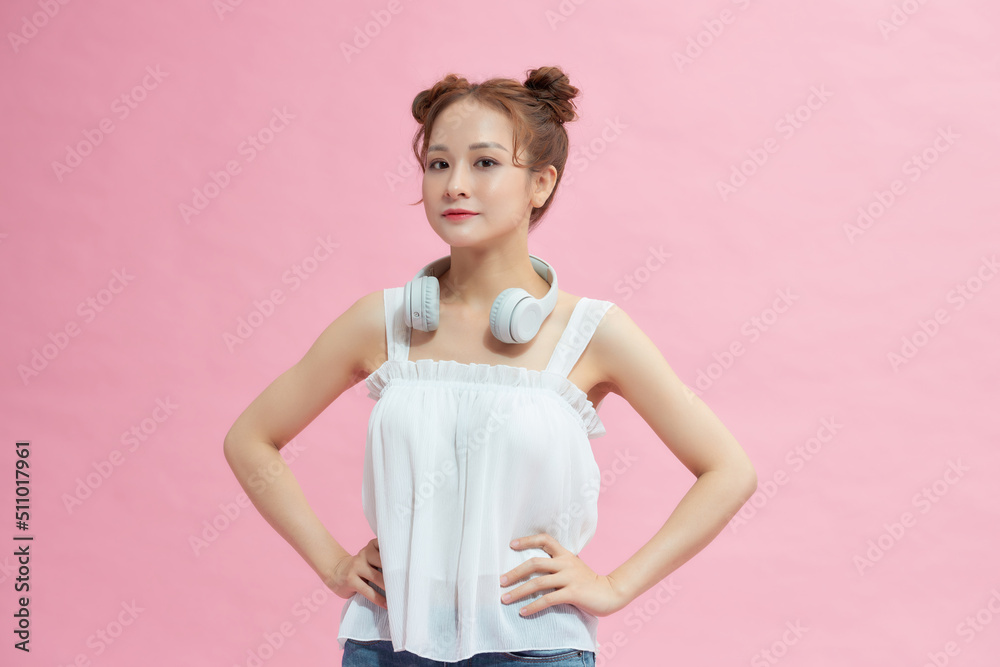 Smiling young woman standing with arms akimbo Smiling young woman standing with arms akimbo