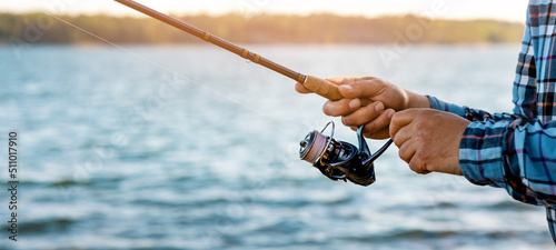 angler retrieve fishing reel line closeup. banner with copy space
