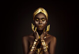 Portrait closeup Beauty fantasy african woman face in gold paint. Golden shiny black skin. Fashion model girl goddess hand fingers posing. Arab turban jewellery bracelets. Professional metallic makeup