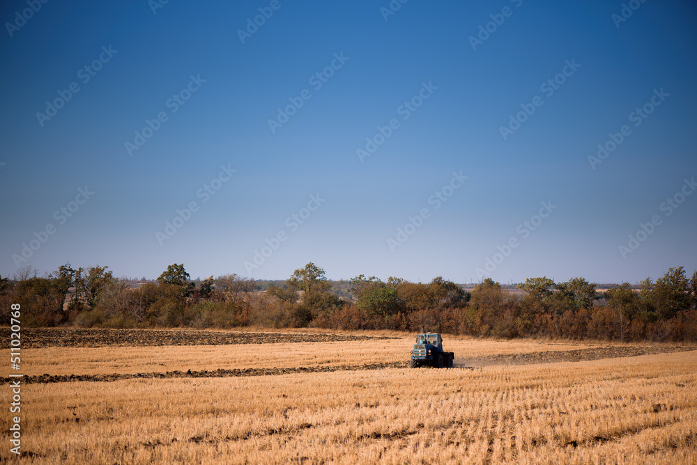 the tractor plows the field in autumn