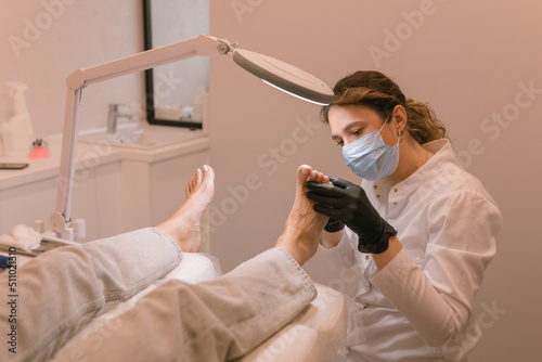 Chiropodist examining the female feet. Healthcare. Woman body care. Spa treatment. photo