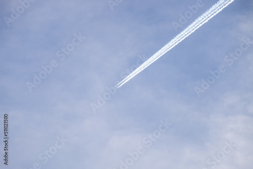 Distant passenger jet plane flying on high altitude on blue sky