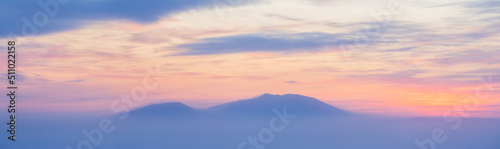 Winter arctic landscape. View of the snow-capped mountains at sunset. Cold winter weather. Frosty fog over the tundra. Arctic nature. Mount Dionysius, Chukotka, Siberia, Far North of Russia. Panorama.