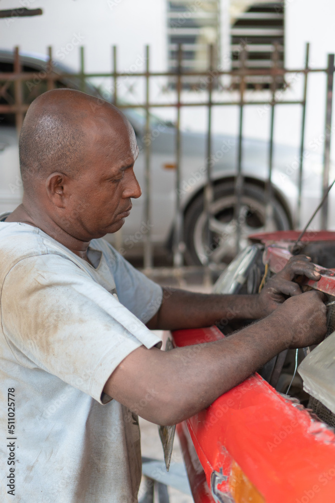 Automobile repair service center. Mechanic repairing a car in the workshop Automobile repair service center. Mechanic repairing a car in the workshop