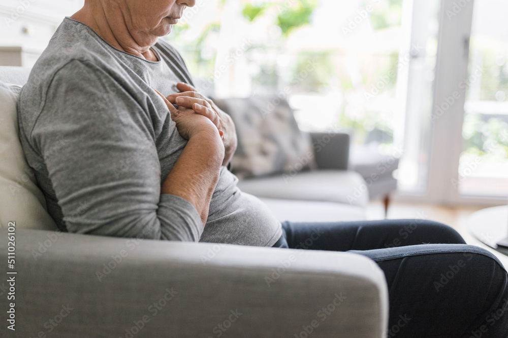 Elderly woman with heart pain holding her chest Elderly woman with heart pain holding her chest