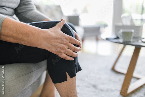 Photography Senior woman holding her painful knee