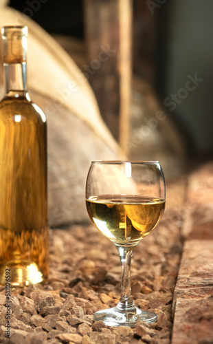 Bottle and glass of white wine in a wine cellar
