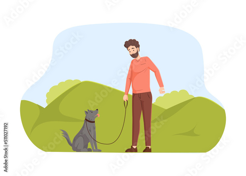 Young man walking with his dog in park. Pet owner looking at dog sitting next to him. Young man walking and training domestic animal. Pet and his owners at city park, outdoor activity 