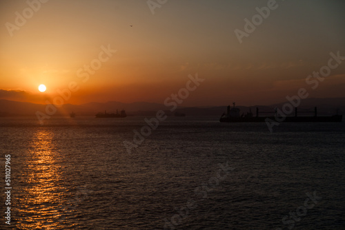 Silhouettes of ships in the bay against the sunset.
