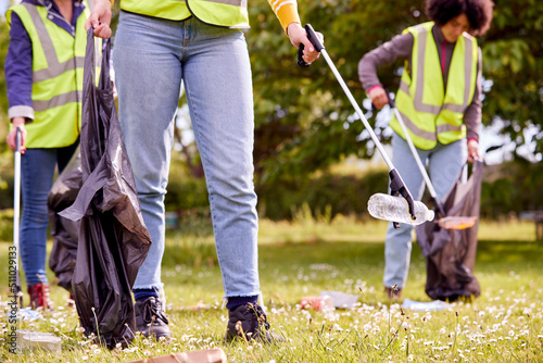 Close Up Of Female Volunteers Picking Up Litter In The Countryside